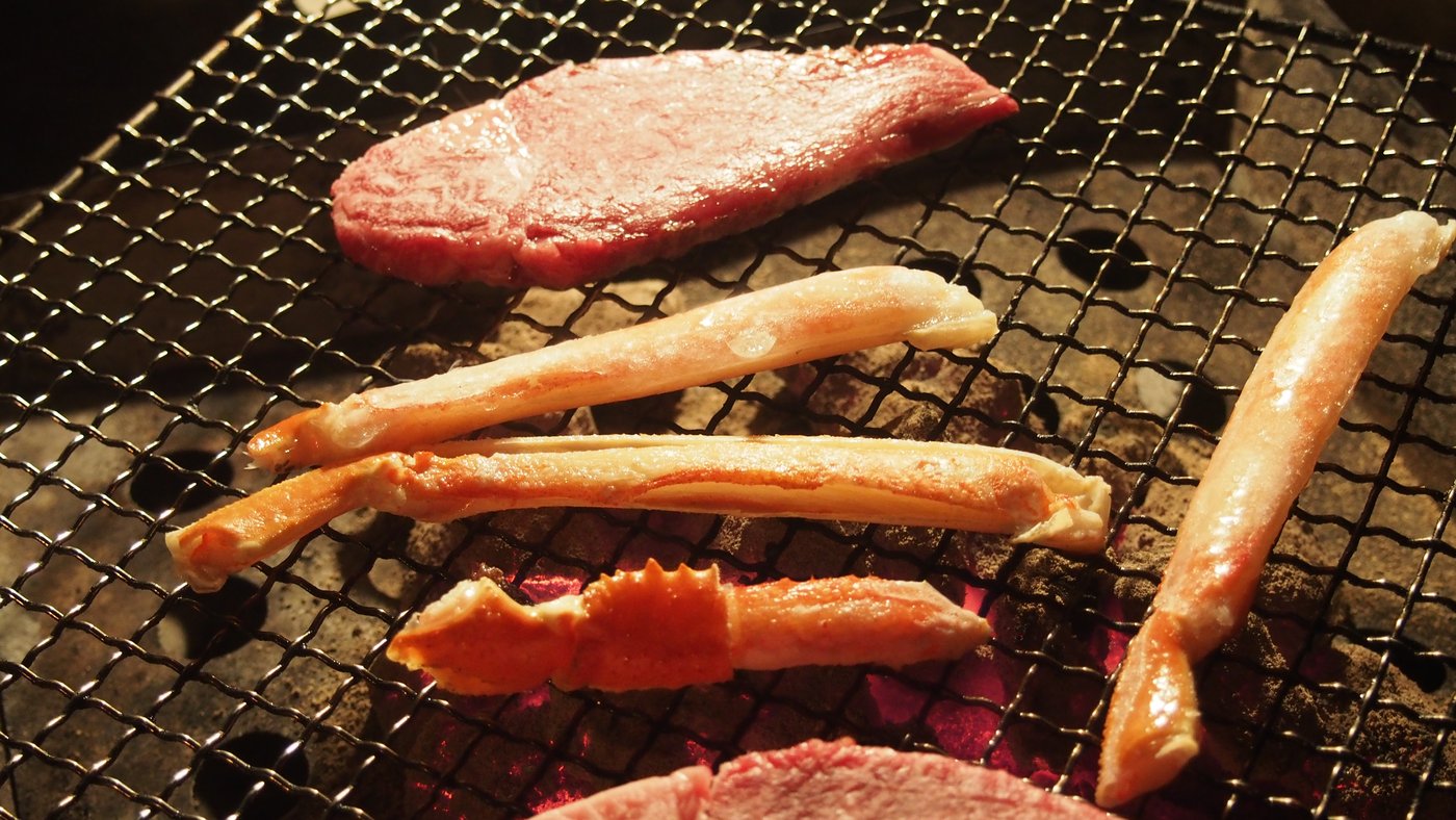 炭火の網で焼いているカニの脚(2019年11月・南紀串本リゾート大島)
